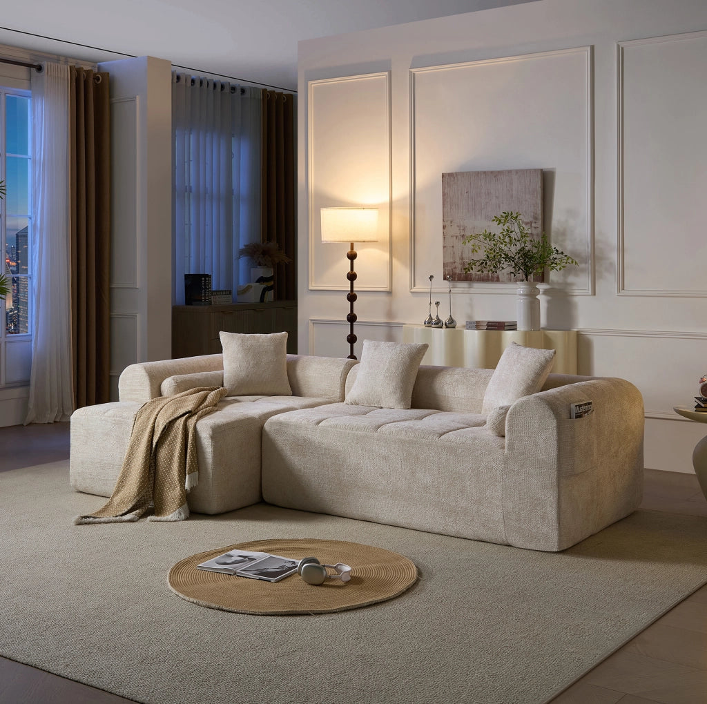 Divano angolare IVMEU da 263 cm in ciniglia beige, con braccioli curvi e tasca laterale